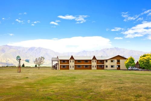 a large building with mountains in the background at Discovery Countrytime Hotel in Omarama
