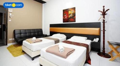 a room with three beds and a couch at Lai Ming Hotel Cosmoland in Singapore
