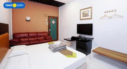 a room with a bed and a couch and a television at Lai Ming Hotel Cosmoland in Singapore