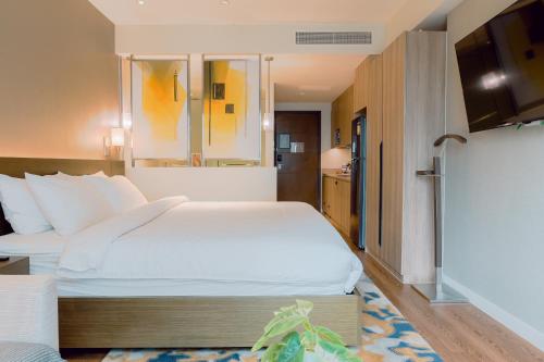 a hotel room with a large bed and a bathroom at The Residences at Novotel Tower in Manila