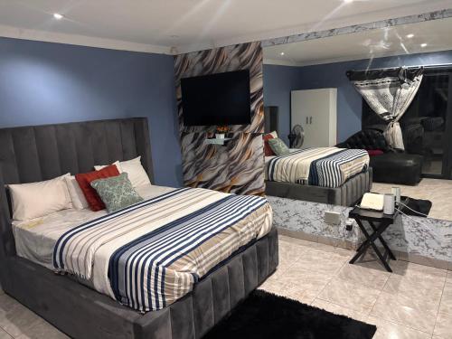 Un dormitorio con dos camas y un televisor de pantalla plana. en Brown Accomodation, en Cape Town