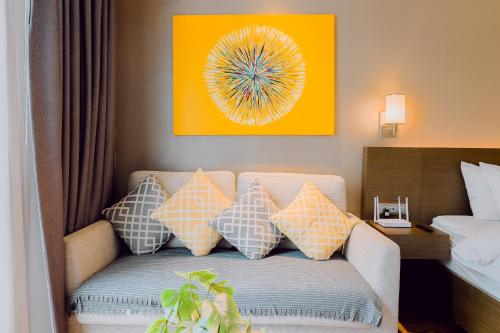 a couch with pillows in a hotel room at The Residences at Novotel Tower in Manila