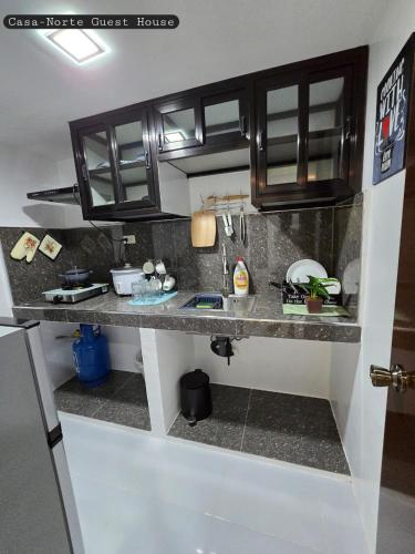 a kitchen with black cabinets and a counter top at Casa-Norte Guest House 