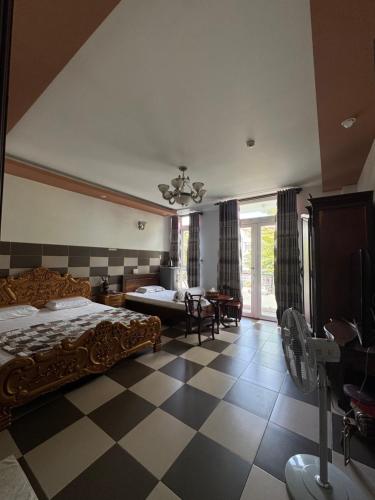 a bedroom with a bed and a checkered floor at Khách sạn Hoàng Oanh in Ấp Rạch Mẹo