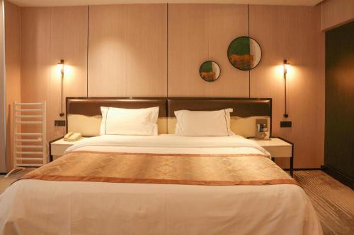 a bedroom with a large bed with two tables and two mirrors at Golden Central Hotel Shenzhen in Shenzhen