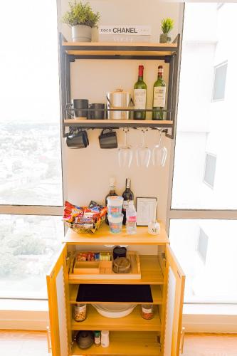 a small cabinet with bottles of wine and food at The Residences at Novotel Tower in Manila