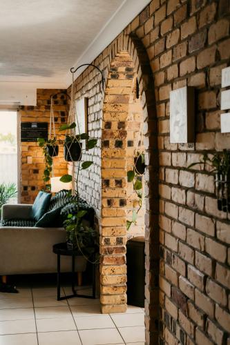 an archway in a brick wall in a living room at Kennedy Drive Boutique Motel - Close To City Centre & Airport in Tweed Heads