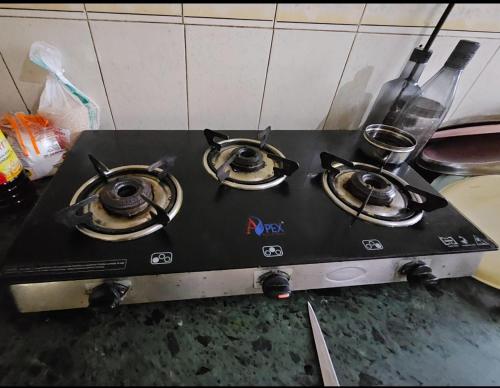 a stove top with three burners on top of it at Ac Private Room At ovale naka Ghodbunder road Thane West in Thane