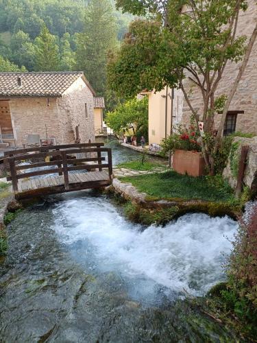 a wooden bridge over a river with water rushing at A casa di Irene in Le Marmore