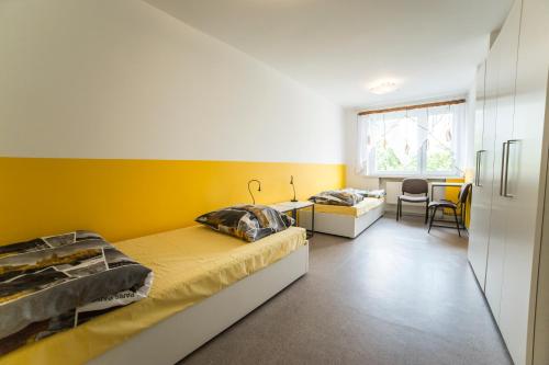 Un dormitorio con dos camas y una pared amarilla. en Klimczoka 6, en Katowice
