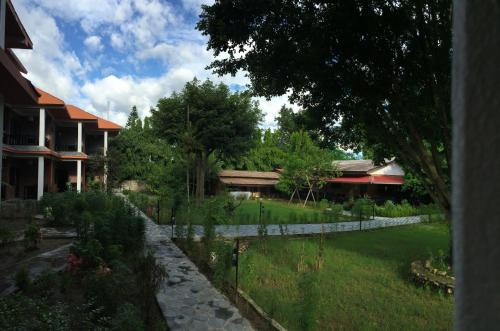 a garden in front of a house with a fence at Chautari Garden Resort in Sauraha