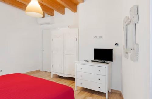 a bedroom with a bed and a tv on a dresser at Le Logge del Garda in San Felice del Benaco