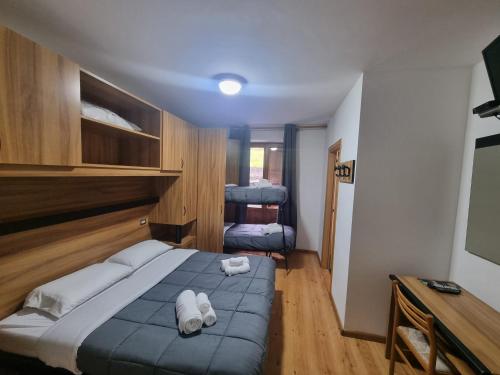 a bedroom with a bed with towels on it at TEA San Pellegrino - DOLOMITI in Falcade