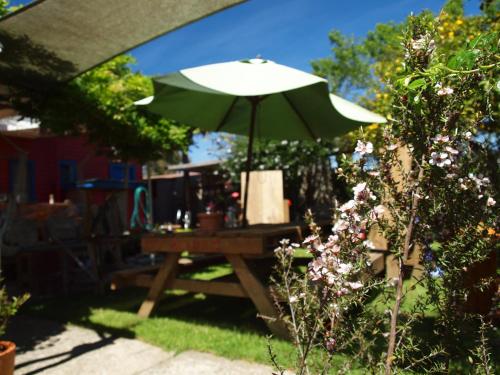 a green umbrella sitting on a picnic table at Annies Nirvana Lodge Backpackers in Takaka
