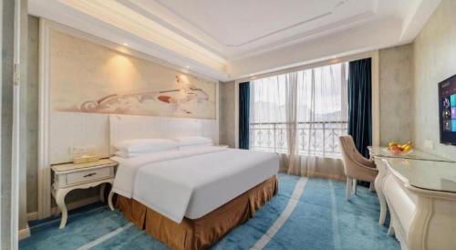 a bedroom with a large bed and a large window at Vienna Hotel Guiyang Jiaxiulou Jichang Road in Guiyang