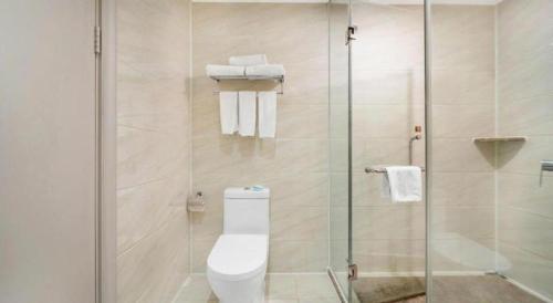 a bathroom with a toilet and a glass shower at Vienna Hotel Guiyang Jiaxiulou Jichang Road in Guiyang