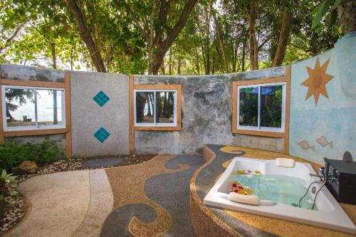 a bathroom with a bath tub in a room with trees at Hotel and Beach Bungalow at Lanta Resort in Ko Lanta