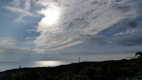 a cloudy sky over the water and a hill at Minnsyuku Yakushimaya in Yakushima