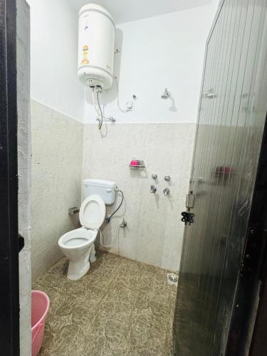 a bathroom with a toilet and a water tank at Satya Yoga Ashram Rishikesh in Narendranagar