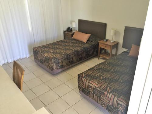 ein Hotelzimmer mit 2 Betten und einem Sofa in der Unterkunft Swag Motel in Middlemount