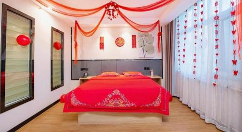 a bedroom with a red bed with red decorations at GreenTree Inn Puyang Pushang Huanghe Road in Puyang