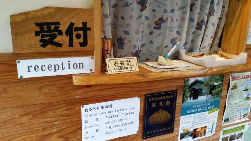 a display of signs and books on a shelf at Minnsyuku Yakushimaya in Yakushima
