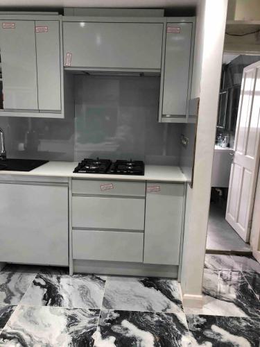 a kitchen with white cabinets and a stove at 96TR Comfy room with double bed Edmonton Green in Edmonton