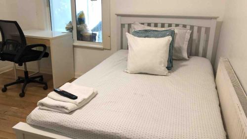 a bedroom with a bed with a remote control on it at 96TR Comfy room with double bed Edmonton Green in Edmonton