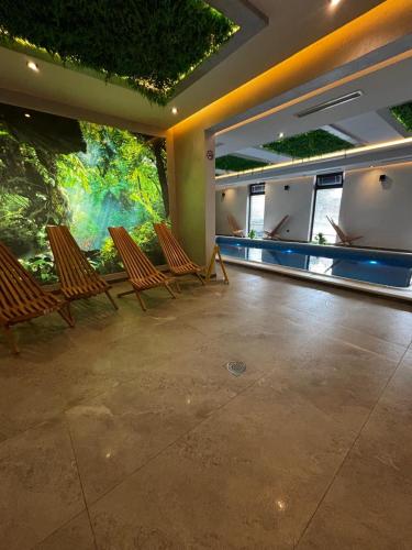 a room with three chairs and an aquarium at Panorama Tornik S3 in Zlatibor
