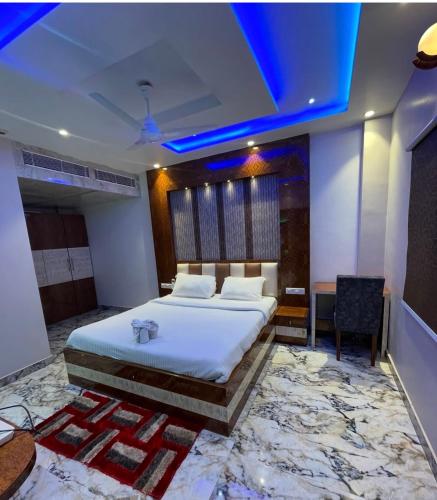 1 dormitorio con 1 cama y techo azul en The Crown Plaza Hotel, en Samastīpur