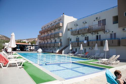 a hotel with a swimming pool next to a building at Hotel Athinoula in Kefalos