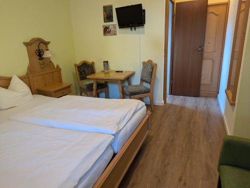 a bedroom with a bed and a table and a television at Jagdhaus Rech - Ahr in Rech