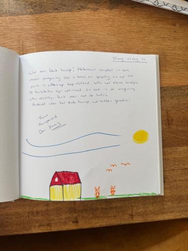a book with a drawing of a house and water at Touch of Yellow in Gramsbergen