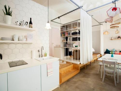 a kitchen and dining room with white cabinets and a table at grätzlhotel Karmelitermarkt in Vienna