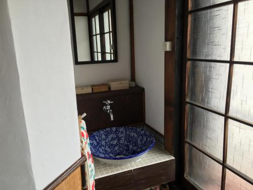 a bathroom with a sink with a blue bowl at Guesthouse Kiten in Gifu