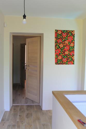 a kitchen with a painting hanging on the wall at Apartamentai Tarp trijų ežerų in Tytuvėnai