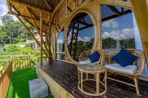 a porch with wicker chairs and a table at Velonia Iseh in Sidemen
