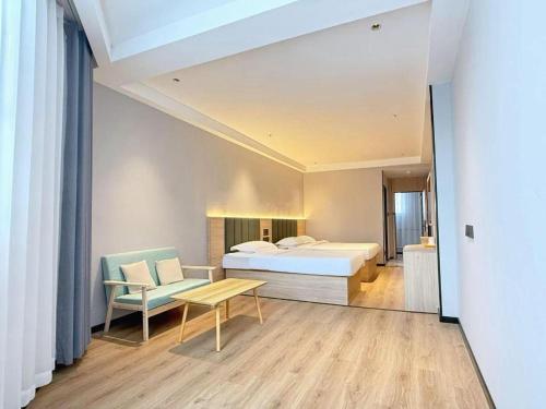 une chambre avec un lit, une table et une chaise dans l'établissement GreenTree Inn Jiangsu Xuzhou Jinshan Bridge Building Jinqiao Road Express Hotel, à Xuzhou