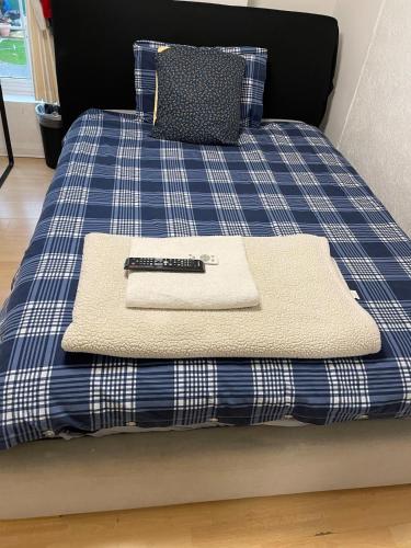 a blue and white bed with a remote control on it at 96TR Double bed bedroom - Edmonton green in Edmonton