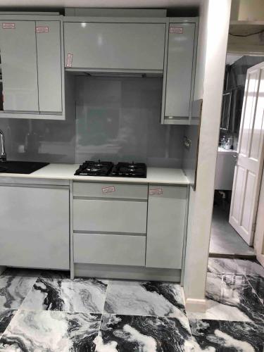 a kitchen with white cabinets and a stove at 96TR Double bed bedroom - Edmonton green in Edmonton