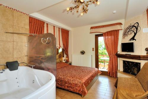 a bathroom with a tub and a bedroom with a bed at Nikolaou House in Tsagarada