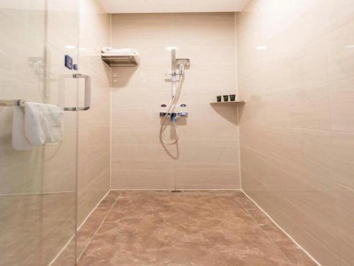a bathroom with a shower with a glass door at Kyriad Marvelous Hotel·Xi'an North High-speed Railway Station in Xi'an