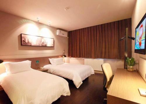 a hotel room with two beds and a flat screen tv at Jinjiang Inn Xi'an Zhonglou North Street Metro Station in Xi'an