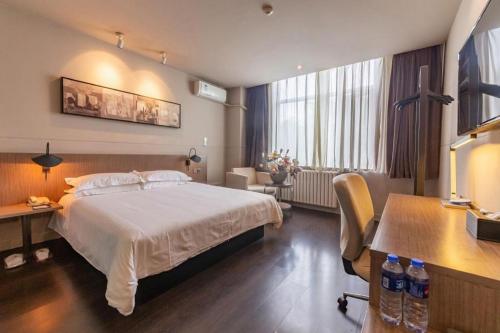 a hotel room with a bed and a desk and a desk at Jinjiang Inn Xi'an Zhonglou North Street Metro Station in Xi'an