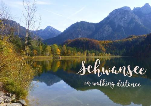 a lake in the mountains with the words seclusion in walking distance at King Ludwig's Old Neighbour in Schwangau