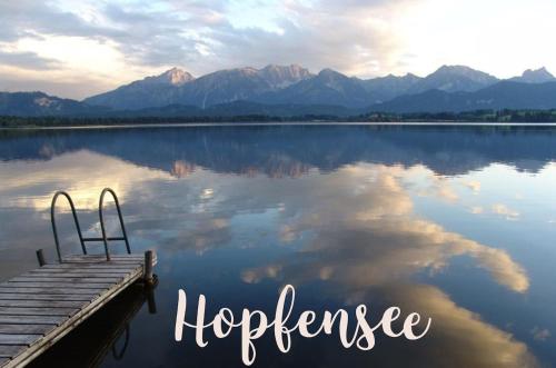 a dock on a lake with mountains in the background at King Ludwig's Old Neighbour in Schwangau