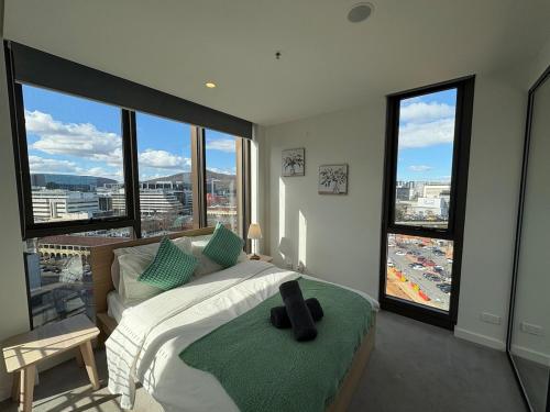 a bedroom with a bed with a view of a city at Canberra CBD modern new 2B apartment free Parking in Canberra