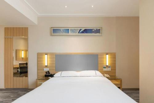 a large white bed in a hotel room at City Comfort Inn Wuhan High Speed Railway Station in Wuhan