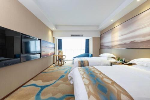 a hotel room with two beds and a flat screen tv at Guilin Manhatton Hotel Tianjie in Guilin