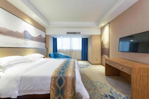a hotel room with a bed and a flat screen tv at Guilin Manhatton Hotel Tianjie in Guilin